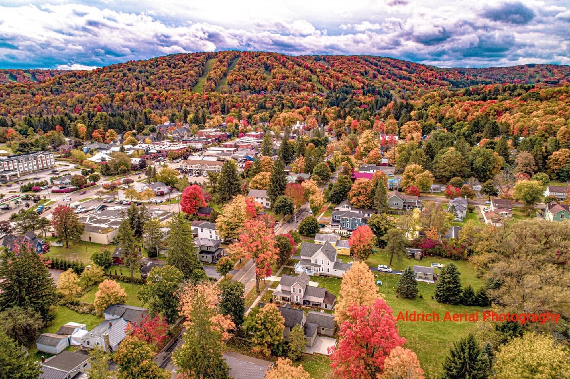 Aerial view of Ellicottville village and hills in peak fall color