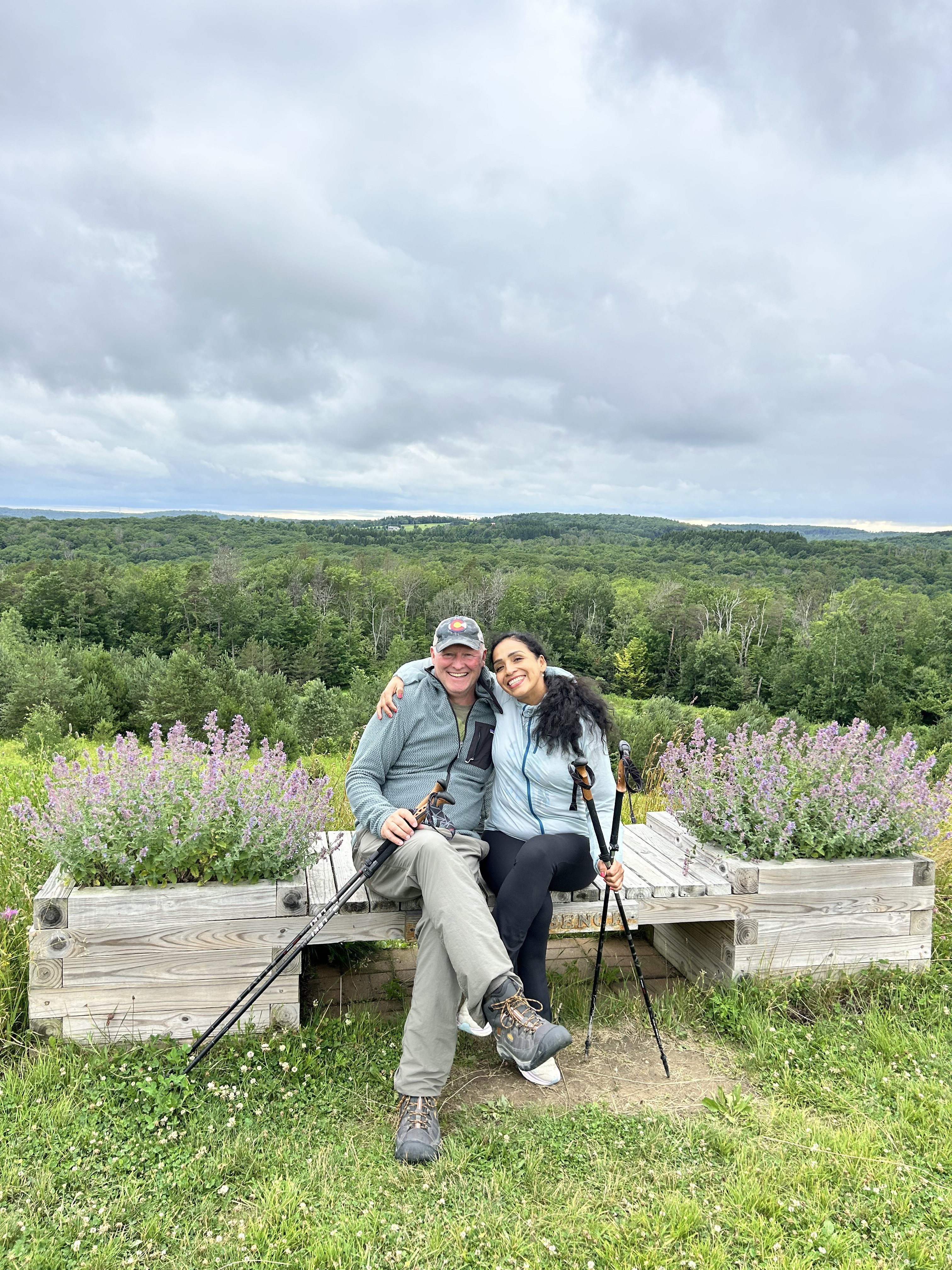 Two hikers with trekking poles at a scenic overlook above the forest near Ellicottville