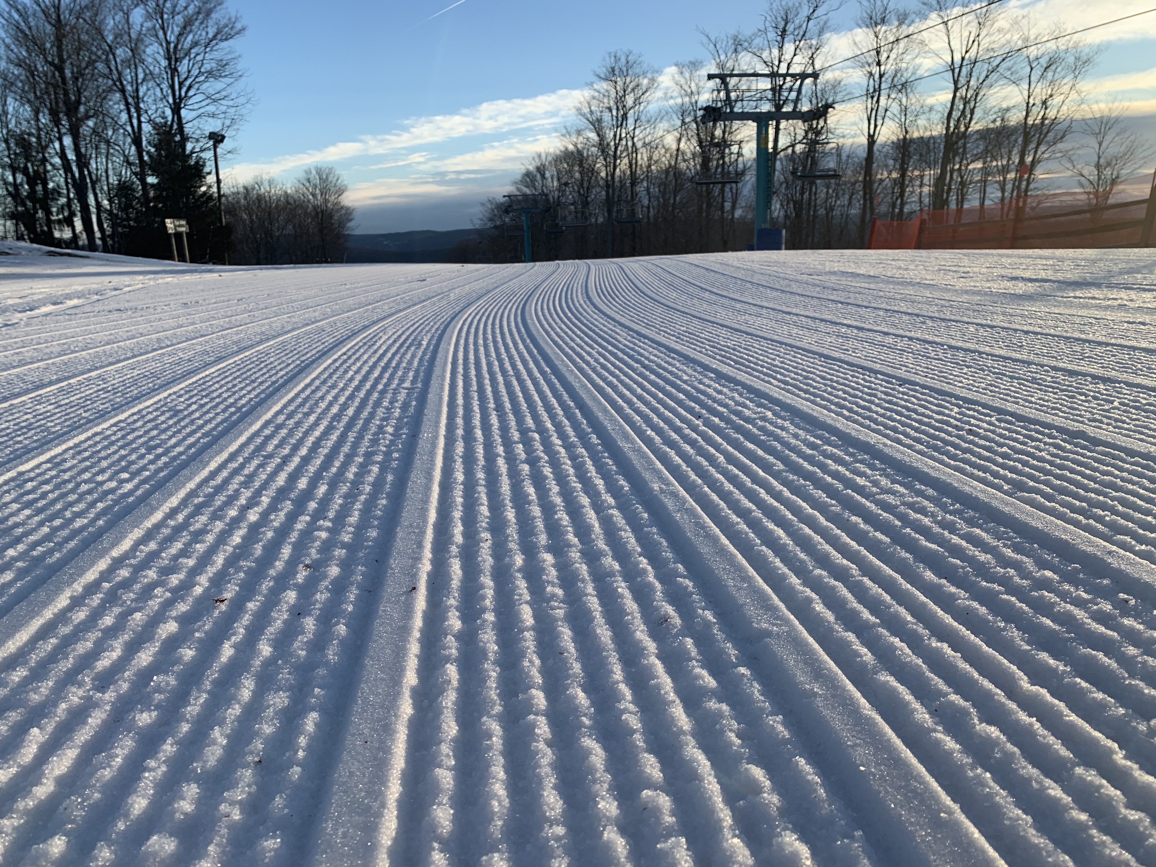Fresh corduroy grooming lines on a ski run at dawn in Ellicottville